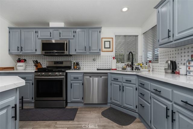 a kitchen with stainless steel appliances granite countertop a stove sink microwave and cabinets
