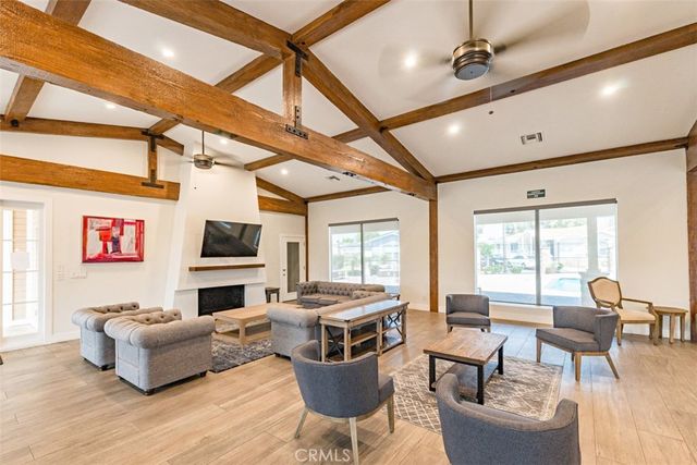 a living room with furniture a flat screen tv and a large window