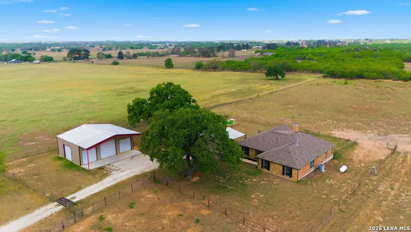 an aerial view of a house with a yard and lake view