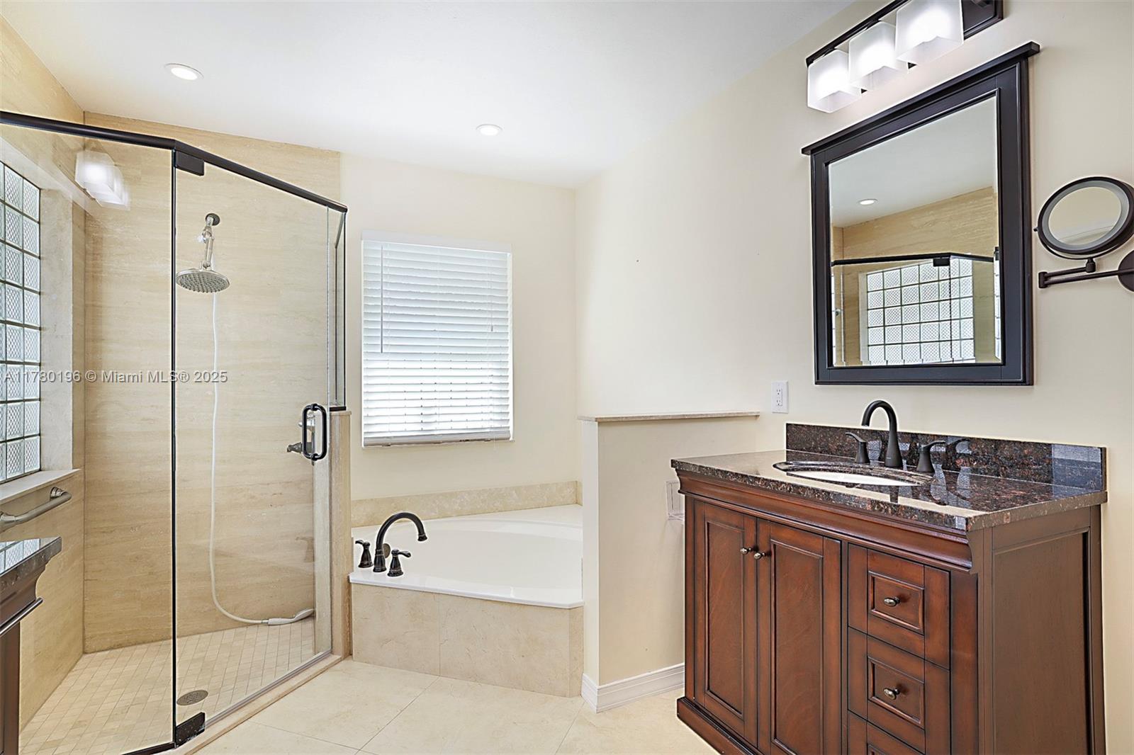 18295 Lake Bend Drive Jupiter, FL 33458 - Photo 28 of 64 a bathroom with a tub sink and mirror