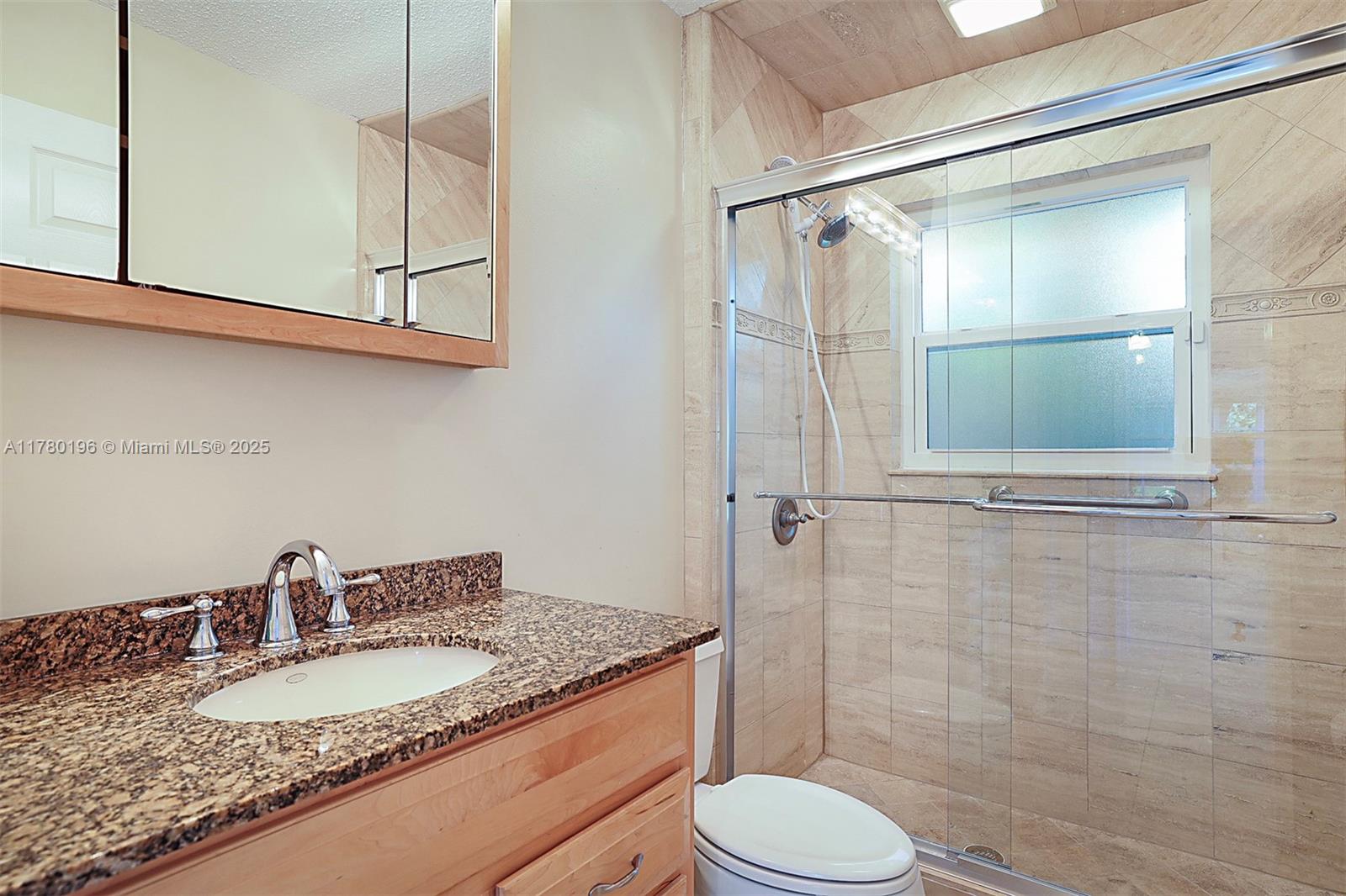 18295 Lake Bend Drive Jupiter, FL 33458 - Photo 33 of 64 a bathroom with a granite countertop sink toilet and shower