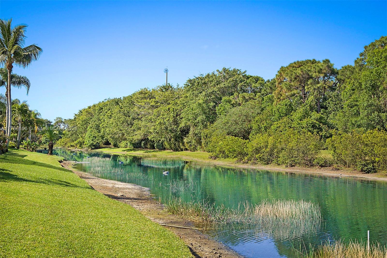 18295 Lake Bend Drive Jupiter, FL 33458 - Photo 46 of 64 a view of a lake with a building in the background