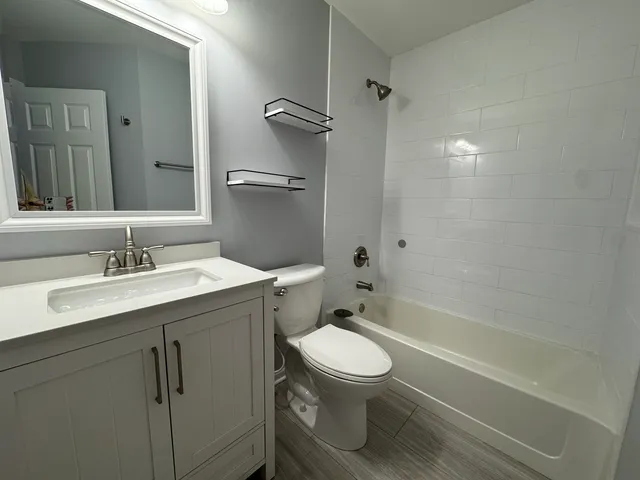 a bathroom with a sink toilet vanity and shower