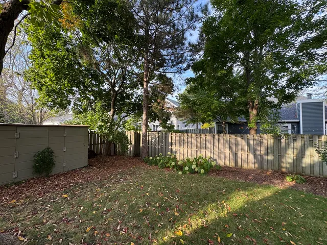a view of backyard with wooden fence