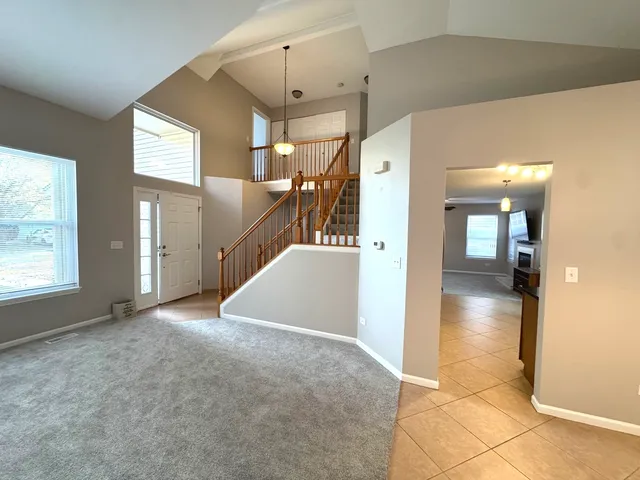 a view of a hallway view with wooden floor and a living room
