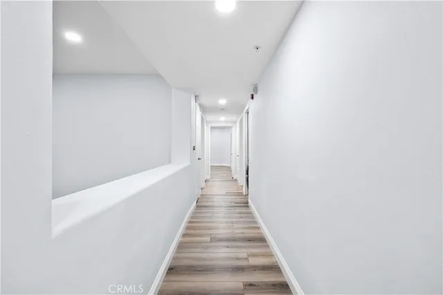 a view of a hallway with wooden floor