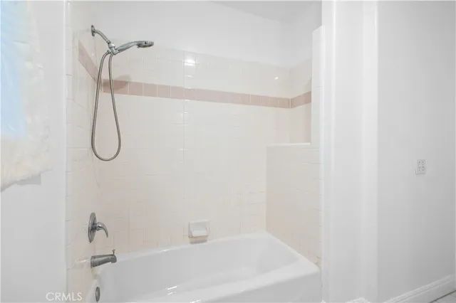 a bathroom with a bath tub with a shower