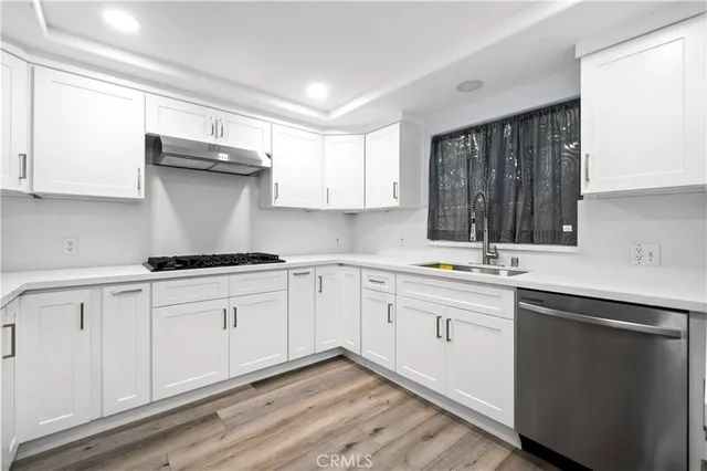 a kitchen with granite countertop white cabinets and a sink