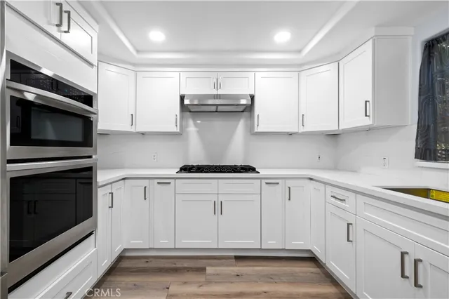 a kitchen with stainless steel appliances granite countertop a stove a microwave and a white cabinets