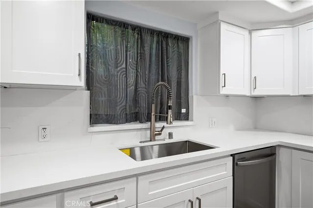 a kitchen with stainless steel appliances a sink a refrigerator and cabinets