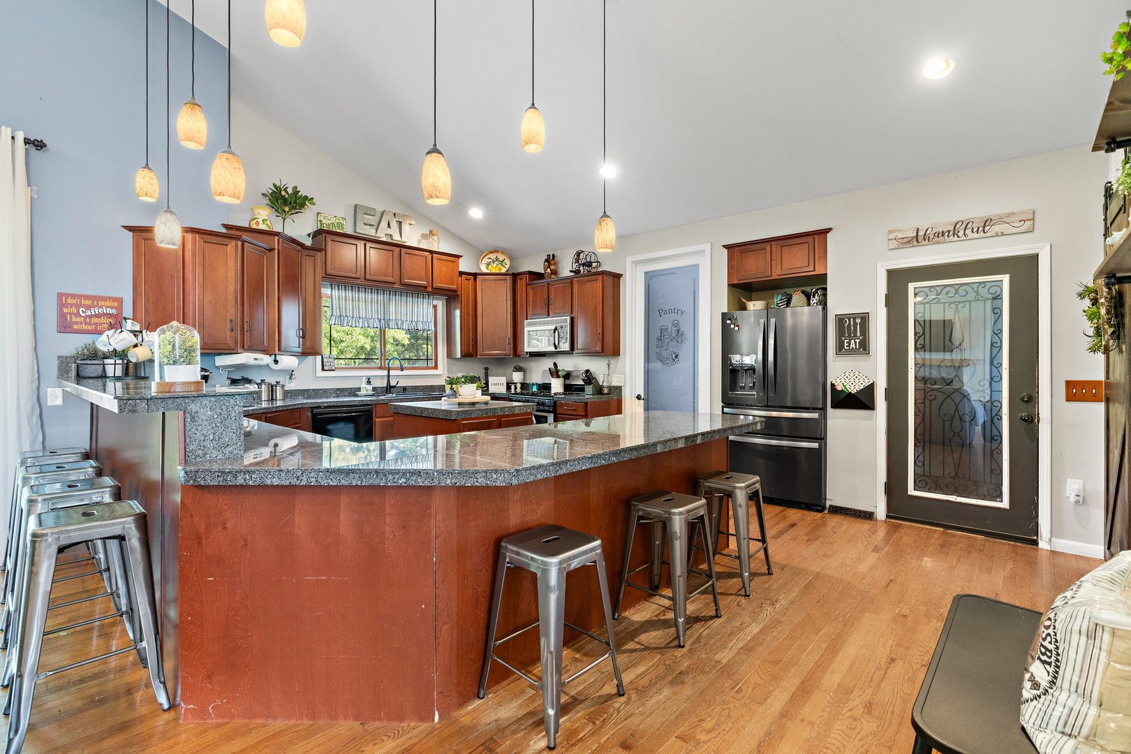 1212 Sycamore Road DeKalb, IL 60115 - Photo 11 of 44 a kitchen with stainless steel appliances a dining table chairs and a refrigerator