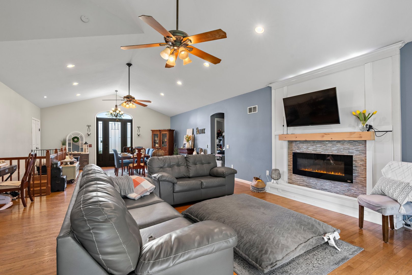 1212 Sycamore Road DeKalb, IL 60115 - Photo 8 of 44 a living room with furniture a flat screen tv and a fireplace