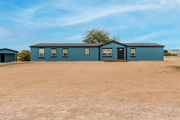 a front view of a house with a yard and trees