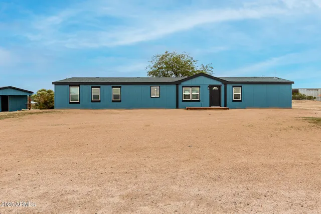a front view of a house with a yard and trees