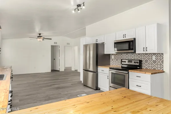 a large kitchen with granite countertop a refrigerator and a stove top oven