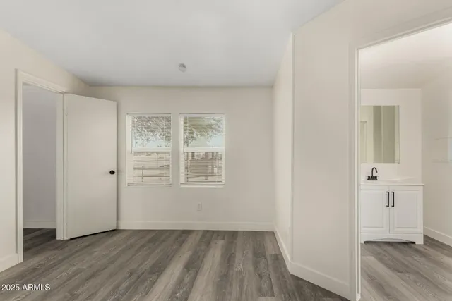 a view of an empty room with wooden floor and closet