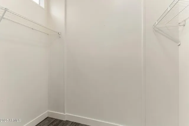 an empty room with wooden floor and ceiling fan