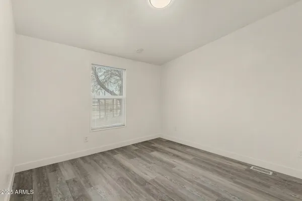 a backyard of a house with large trees and outdoor seating