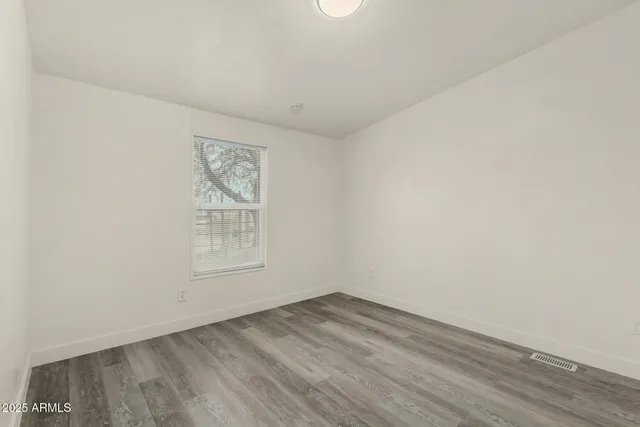 a backyard of a house with large trees and outdoor seating