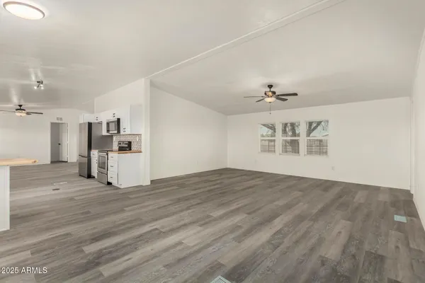 a view of an empty room with a kitchen