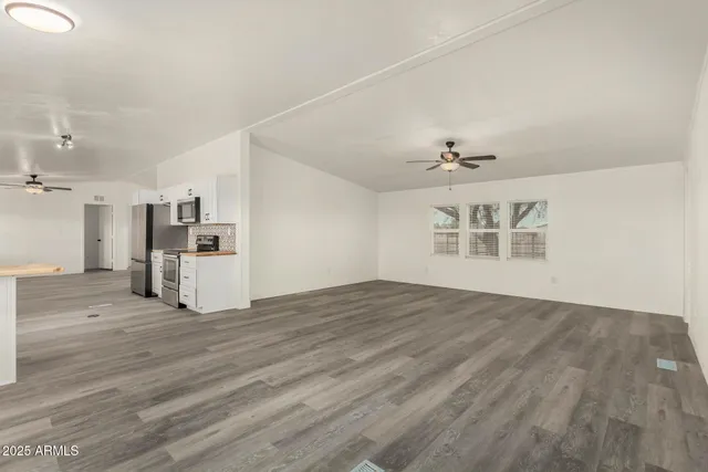 a view of an empty room with a kitchen