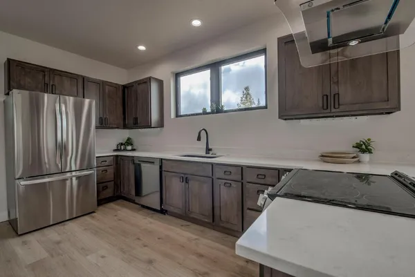 a kitchen with stainless steel appliances a sink cabinets and wooden floor