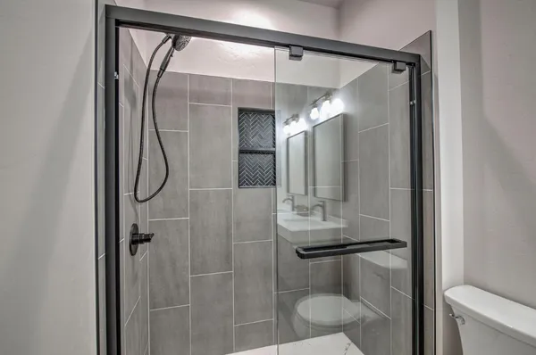 a bathroom with a mirror shower and toilet