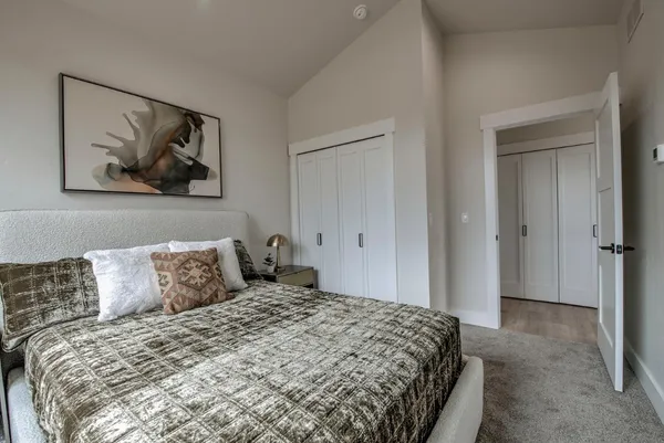 a bedroom with a bed and painting on the wall