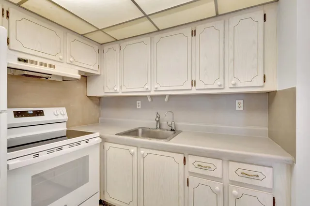 a kitchen with white cabinets and white appliances