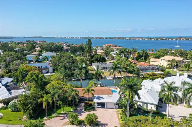 a view of a house with a yard and palm trees