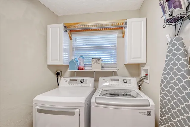 a view of a swimming pool with a patio and a lawn chairs