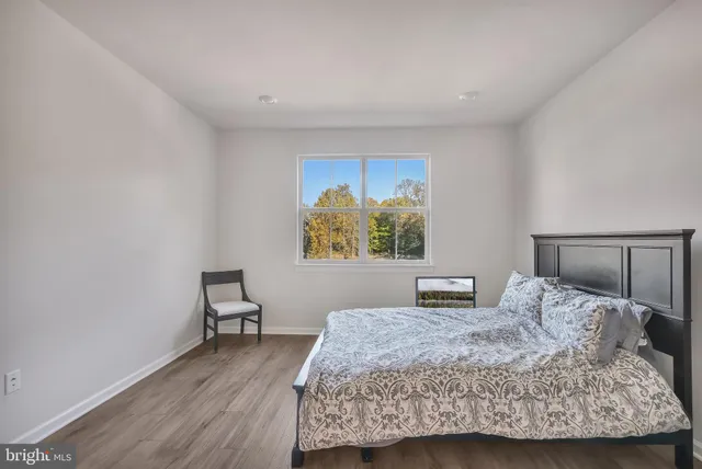 a bedroom with a bed and a lamp on dresser