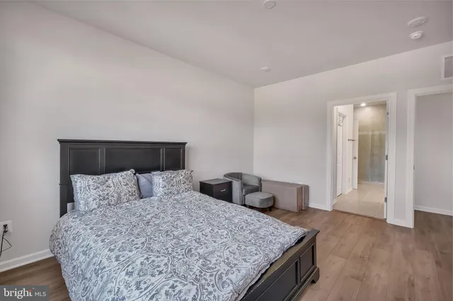 a bedroom with a bed and wooden floor