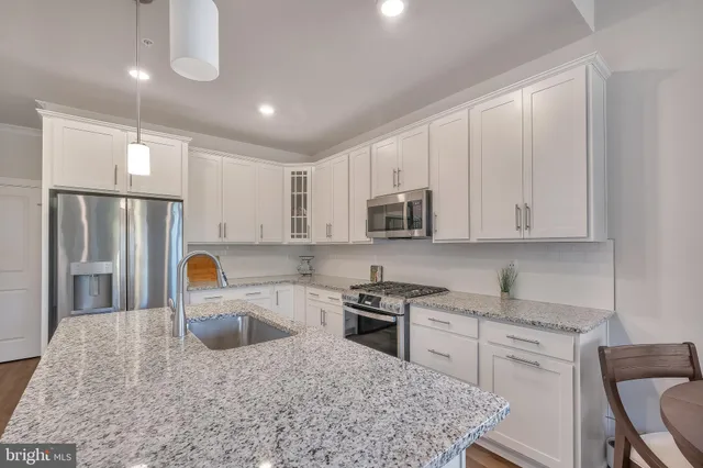 a kitchen with stainless steel appliances granite countertop a refrigerator sink stove microwave and cabinets