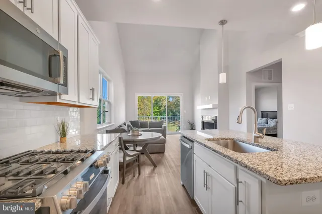 a kitchen with stainless steel appliances granite countertop a sink stove and cabinets