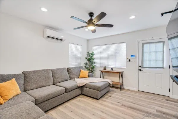 a living room with furniture and a wooden floor