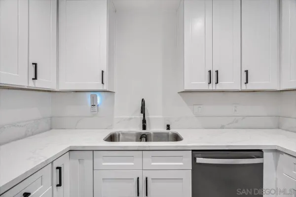 a kitchen with white cabinets and a sink