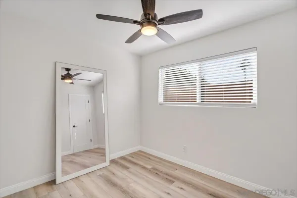 an empty room with a window and a fan