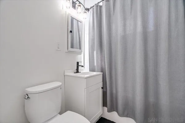 a bathroom with a sink a toilet and shower curtain