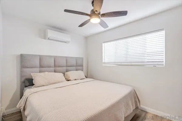 a bedroom with two beds and ceiling fan