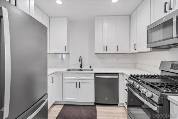 a kitchen with stainless steel appliances granite countertop a stove and a microwave