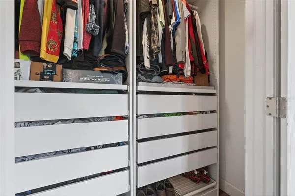 a view of walk in closet with clothes and shoes