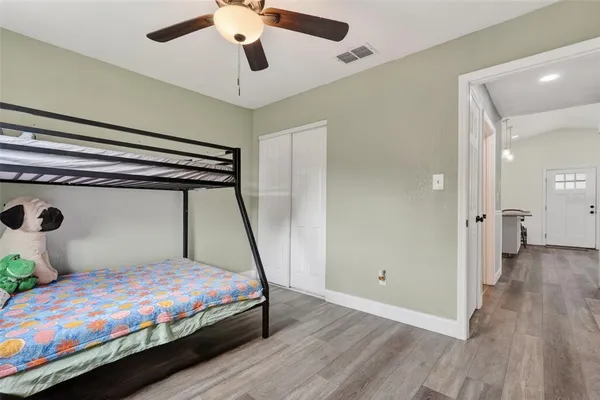 a bedroom with a bed and wooden floor