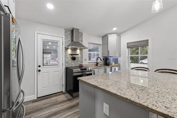 a kitchen with stainless steel appliances granite countertop a sink stove and refrigerator