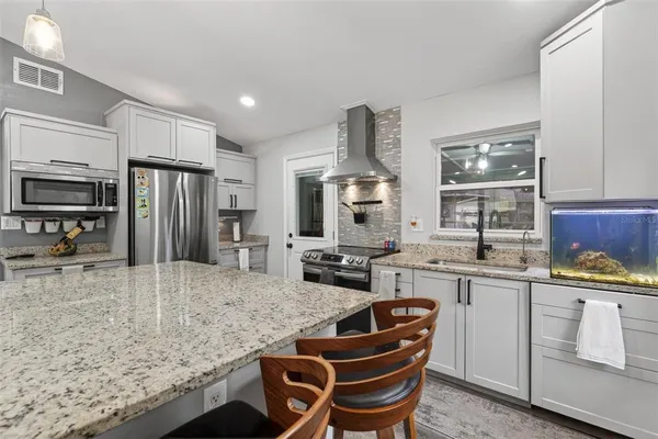 a kitchen with stainless steel appliances granite countertop a sink stove and refrigerator