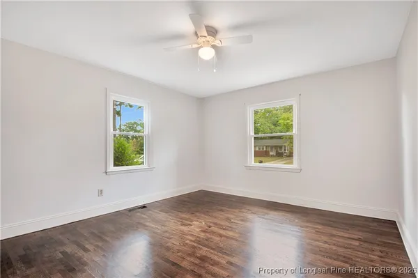 an empty room with window and wooden floor
