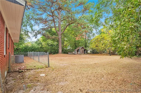 a backyard of a house with a swing and tree
