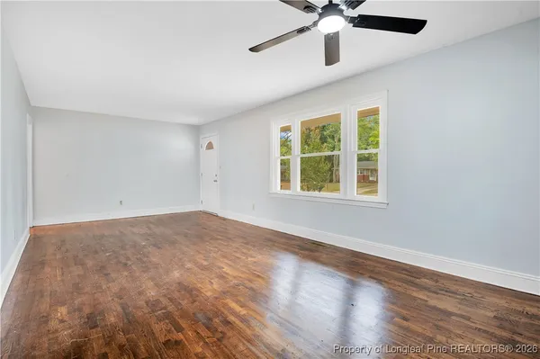 wooden floor in an empty room with a window