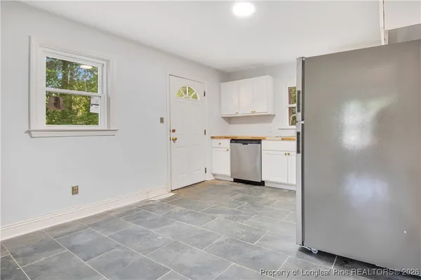 a view of a kitchen with white cabinets and white appliances