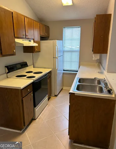 a kitchen with a sink a stove and refrigerator